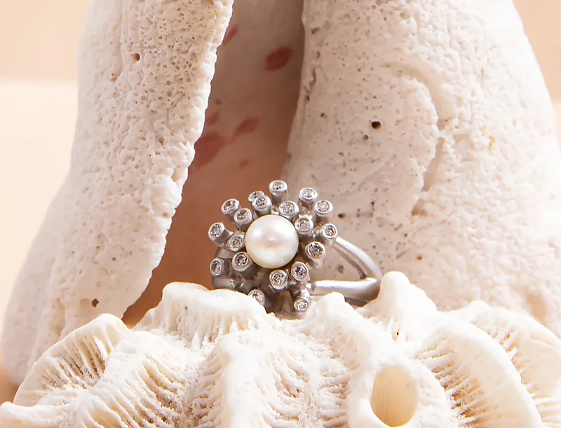 Pearl and diamond ring nestled in white coral